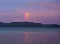 夕暮れの海辺に淡い虹がそっと立ち上がる静かな風景｜懐かしい情景が静かによみがえる、やさしい記憶のイメージ写真