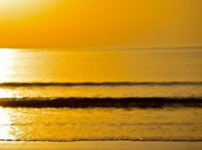 夕暮れの海に柔らかな黄金の光が広がる静かな浜辺の風景｜懐かしい情景が静かによみがえる、やさしい記憶のイメージ写真
